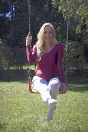 Busty blonde Hayley Marie Coppin strips bodysuit and white pantyhose outdoors on girlsabc.com