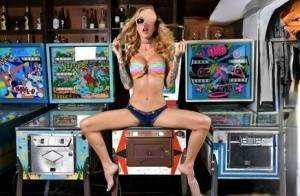 Inked chick Sarah Jessie toys her pussy atop a pinball machine while alone on girlsabc.com
