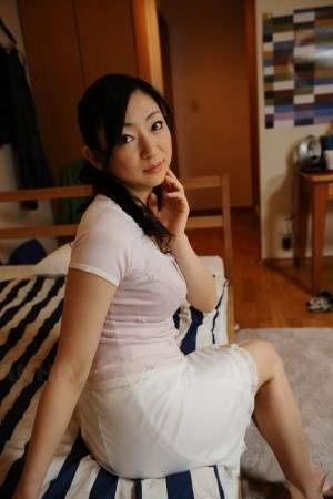 Slender mature Japanese woman Emiko Koike bends over to pose in white dress - Japan on girlsabc.com